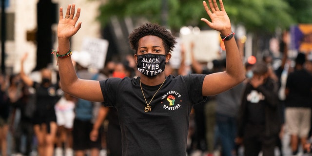 A man holds up his hands while marching following the guilty verdict in the trial of Derek Chauvin on April 20, 2021, in Atlanta, Georgia. 