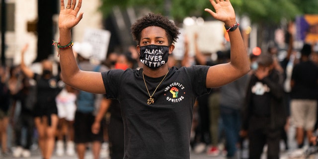 Un hombre levanta las manos mientras marcha tras el veredicto de culpabilidad en el juicio de Derek Chauvin el 20 de abril de 2021 en Atlanta, Georgia. 