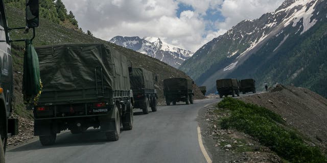 An Indian army convoy carrying reinforcements and supplies travels toward Leh through Zoji La, a high mountain pass bordering China, in Ladakh, India, on June 13, 2021.