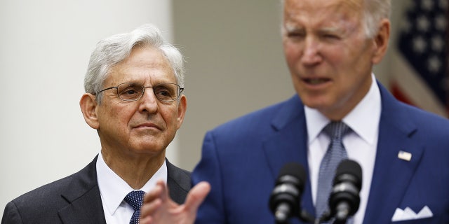 Merrick Garland looks at Joe Biden