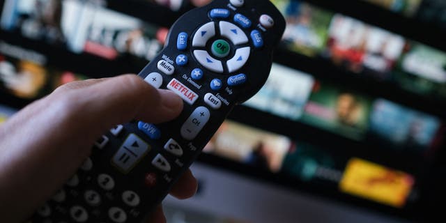 Dalam foto ilustrasi yang diambil pada 19 Juli 2022 ini, logo Netflix terlihat di remote TV di Los Angeles.