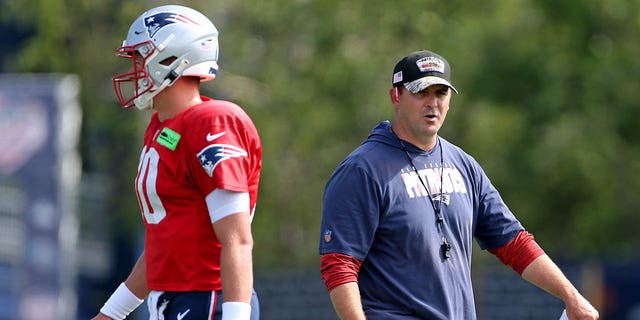 Patriots quarterbacks coach Joe Judge, right, works with Mac Jones during training camp on Aug. 1, 2022 in Foxborough, Massachusetts.