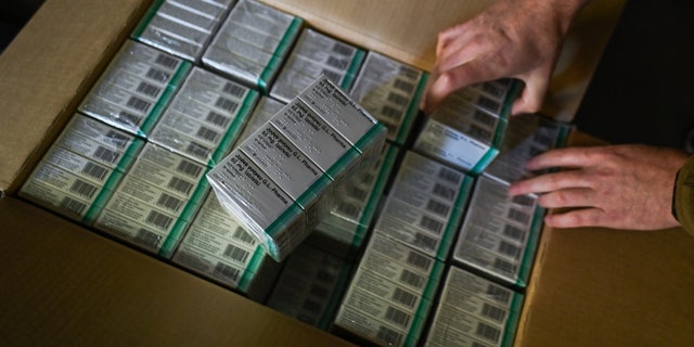 Marcin Rossak, a local firefighter opens a box of iodine tablets in Milanowek Fire station, one of the distribution points, in Milanowek, Poland on October 10, 2022.