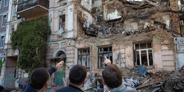 Orang-orang melihat bangunan tempat tinggal yang dihancurkan oleh serangan pesawat tak berawak Rusia.  Sedikitnya empat orang tewas akibat serangan pesawat tak berawak di sebuah bangunan tempat tinggal di Kyiv, Ukraina pada pagi hari tanggal 17 Oktober 2022. 