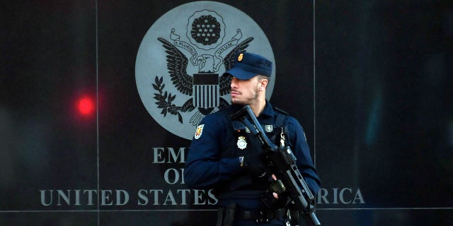 A Spanish policeman stands guard near the US embassy in Madrid, on December 1, 2022, after they have received a letter bomb, similar to one which went off at the Ukrainian embassy.
