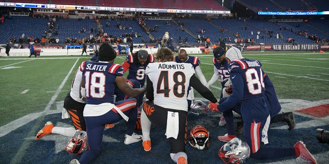 New England Patriots wide receiver Matthew Slater, #18, Cincinnati Bengals long snapper Cal Adomitis, #48, New England Patriots wide receiver Kendrick Bourne, #84, New England Patriots linebacker Josh Uche, #55, New England Patriots free safety Devin McCourty, #32, and New England Patriots outside linebacker Matt Judon, #9, pray together after of a game between the New England Patriots and the Cincinnati Bengals on December 24, 2022, at Gillette Stadium in Foxborough, Massachusetts. The Bengals defeated the Patriots 22-18.