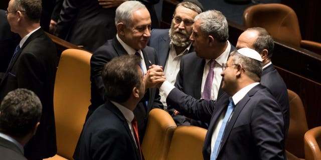 Israeli Prime Minister Benjamin Netanyahu and Minister of National Security Itamar Ben-Gvir react after sworn in at the Israeli parliament during a new government sworn in discussion at the Israeli parliament on Dec. 29, 2022 in Jerusalem.