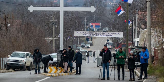 Kosovo media are seen as Kosovo Serbs begin removal of barricades set up in Mitrovica, Kosovo, on Dec. 29, 2022.