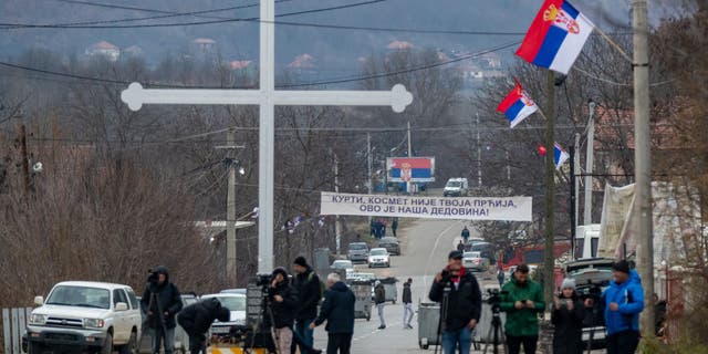 Kosovo media are seen as Kosovo Serbs begin removal of barricades set up in Mitrovica, Kosovo, on Dec. 29, 2022.