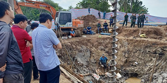 I soccorritori esaminano il sito in cui si ritiene che un bambino di 10 anni sia intrappolato in un pozzo profondo 35 metri in un cantiere di costruzione di ponti nella provincia vietnamita di Dong Thap il 2 gennaio 2023. 