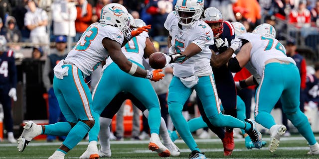 Miami Dolphins quarterback Teddy Bridgewater hands off to running back Jeff Wilson Jr. during the New England Patriots game on Jan. 1, 2023, at Gillette Stadium in Foxboro, Massachusetts.