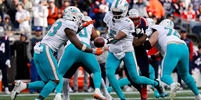 El mariscal de campo de los Miami Dolphins, Teddy Bridgewater, pasa al corredor Jeff Wilson Jr. durante el juego de los New England Patriots el 1 de enero de 2023 en el Gillette Stadium en Foxboro, Massachusetts.