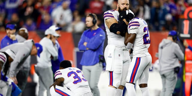 Mitch Morse #60 of the Buffalo Bills consoles Tre'Davious White #27 after Damar Hamlin #3 sustained an injury during the first quarter of an NFL football game against the Cincinnati Bengals at Paycor Stadium on January 2, 2023 in Cincinnati, Ohio. 
