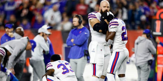 Mitch Morse #60 of the Buffalo Bills consoles Tre'Davious White #27 after Damar Hamlin #3 sustained an injury during the first quarter of an NFL football game against the Cincinnati Bengals at Paycor Stadium on January 2, 2023 in Cincinnati, Ohio. 