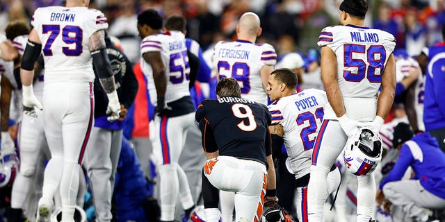 Joe Burrow #9 of the Cincinnati Bengals kneels with Jordan Poyer #21 of the Buffalo Bills after Damar Hamlin #3 sustained an injury during the first quarter of an NFL football game at Paycor Stadium on January 2, 2023 in Cincinnati, Ohio. 