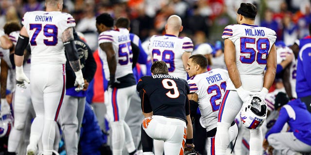 Joe Burrow #9 de los Cincinnati Bengals se arrodilla con Jordan Poyer #21 de los Buffalo Bills después de que Damar Hamlin #3 se lesione durante el primer cuarto de un partido de fútbol americano de la NFL en el Paycor Stadium el 2 de enero de 2023 en Cincinnati, Ohio. 