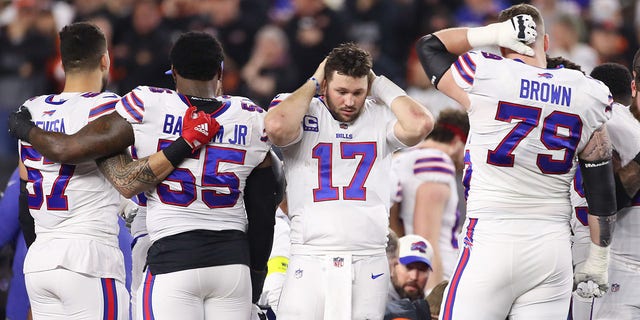 Buffalo Bills A.J. Epenesa (57), Boogie Basham (55), Josh Allen (17) and Spencer Brown (79) react while safety Damar Hamlin (3) is attended to on the field during a game against the Cincinnati Bengals Jan. 2, 2023, at Paycor Stadium in Cincinnati. 