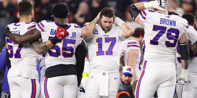 Buffalo Bills AJ Epenesa (57), Boogie Basham (55), Josh Allen (17) y Spencer Brown (79) reaccionan mientras la seguridad Damar Hamlin (3) recibe apoyo en el campo durante un juego contra los Bengals de Cincinnati el 2 de enero.  2023, en el Paycor Stadium de Cincinnati. 