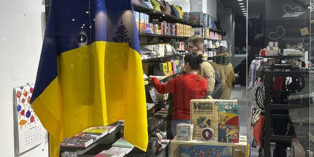 A Ukraine flag hangs in the window of store in a shopping mall in Kyiv, Ukraine, on Thursday, Jan. 5, 2023.