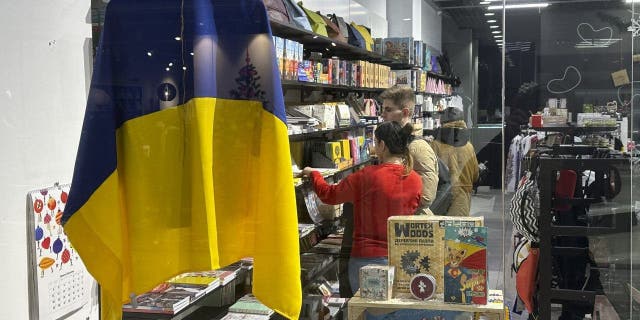 A Ukraine flag hangs in the window of store in a shopping mall in Kyiv, Ukraine, on Thursday, Jan. 5, 2023.