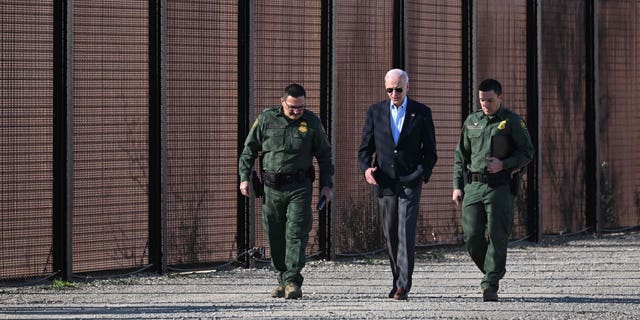 El presidente de los Estados Unidos, Joe Biden, habla con un miembro de la Patrulla Fronteriza de los Estados Unidos mientras caminan a lo largo de la valla fronteriza entre Estados Unidos y México en El Paso, Texas, el 8 de enero de 2023. 