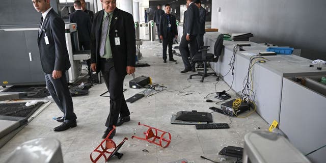 Planalto Presidential Palace security members walk along one of the entrance of the building destroyed by supporters of Brazilian former President Jair Bolsonaro during an invasion in Brasilia on Jan. 9, 2023.