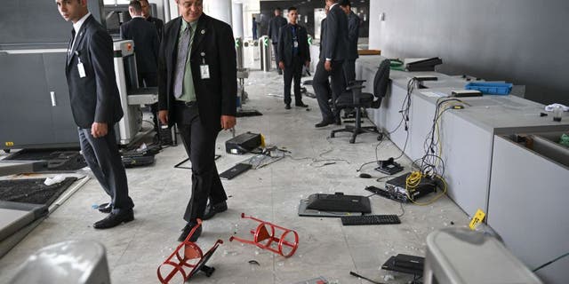 Planalto Presidential Palace security members walk along one of the entrance of the building destroyed by supporters of Brazilian former President Jair Bolsonaro during an invasion in Brasilia on January 9, 2023. (CARL DE SOUZA/AFP via Getty Images)