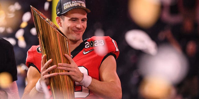 El mariscal de campo de los Georgia Bulldogs, Stetson Bennett (13), sostiene el trofeo del campeonato después de que los Georgia Bulldogs derrotaron a los TCU Horned Frogs en el juego del Campeonato Nacional de Fútbol Universitario el 9 de enero de 2023 en el SoFi Stadium en Inglewood, Utah, California. 