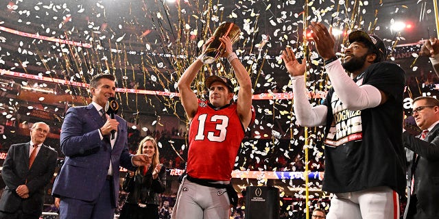 El mariscal de campo de los Georgia Bulldogs, Stetson Bennett, No. 13, sostiene el trofeo del campeonato después de derrotar a los TCU Horned Frogs 65-7 para ganar el partido de fútbol del Campeonato Nacional CFP en el SoFi Stadium en Inglewood el lunes 9 de enero de 2023.