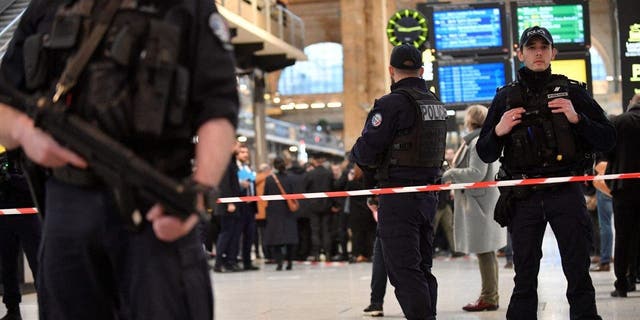 French police stand guard in a cordoned off area at Paris' Gare du Nord train station, after several people were lightly wounded by a man wielding a knife on Jan. 11, 2023.