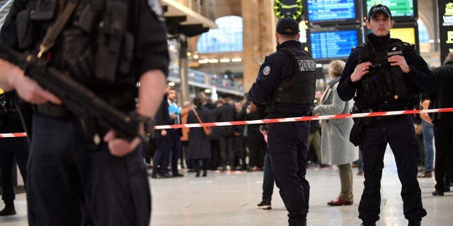French police stand guard in a cordoned off area at Paris' Gare du Nord train station, after several people were lightly wounded by a man wielding a knife on Jan. 11, 2023.