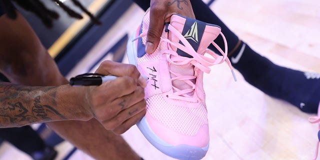 Ja Morant signs his shoes for a fan