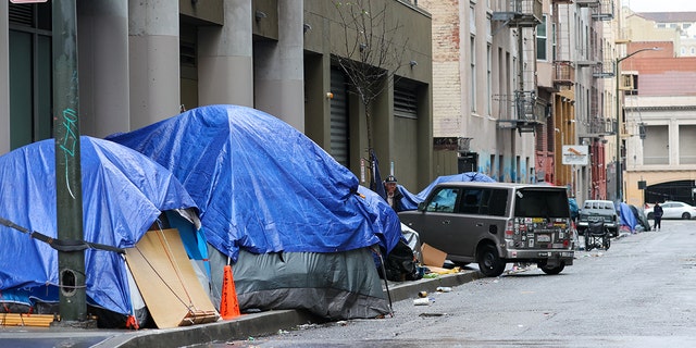 Homeless tents and homeless people are seen by the Polk Street near the City Hall during rainy day in San Francisco on January 13, 2023, as atmospheric river storms hit California, United States. 