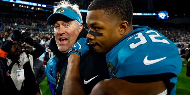 Tyson Campbell #32 of the Jacksonville Jaguars hugs head coach Doug Pederson after beating the Los Angeles Chargers in an NFL wild card playoff football game at TIAA Bank Field on Jan. 14, 2023 in Jacksonville, Florida. 