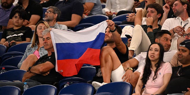 A supporter holds a Russian flag during the match between Marcos Giron and Daniil Medvedev at the Australian Open in Melbourne on January 16, 2023.