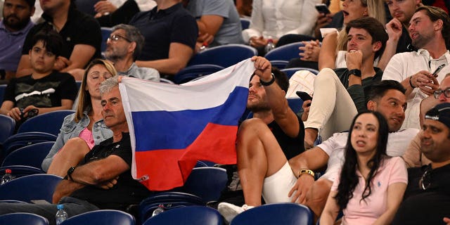 A supporter holds a Russian flag during the match between Marcos Giron and Daniil Medvedev at the Australian Open in Melbourne on January 16, 2023.