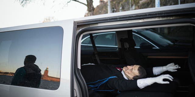 Andreas, 39-year-old, member of the Swedish solidarity committee for Rojava is reflected next to a car carrying an effigy of Turkish President Recep Tayyip Erdogan, on January 16, 2023, in Stockholm, Sweden. - Their action threw another spanner in the works of Sweden's efforts to join NATO and pro-Kurdish activists who hanged on January 11, 2023 an effigy of Turkey's president in Stockholm argue their "provocation" was in the name of free speech. (Photo by Jonathan NACKSTRAND / AFP) 