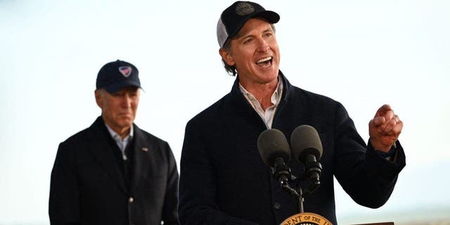 US President Joe Biden (L) listens to California Governor Gavin Newsom deliver remarks after looking at storm damage, and speaking to those affected in Seacliff, California, on January 19, 2023.