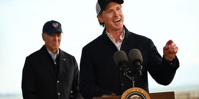 US President Joe Biden (L) listens to California Governor Gavin Newsom deliver remarks after looking at storm damage, and speaking to those affected in Seacliff, California, on January 19, 2023.