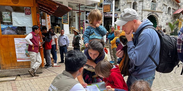 Tourists queue to sign a petition to the railroad company to be evacuated on a "humanitary train" in Machu Picchu, Peru, on January 20, 2023. -