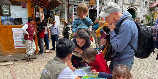 Tourists queue to sign a petition to the railroad company to be evacuated on a "humanitary train" in Machu Picchu, Peru, on January 20, 2023. -