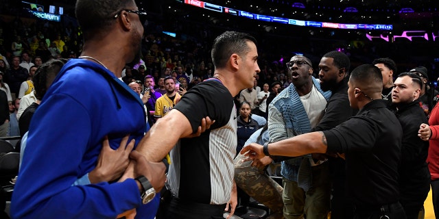 LOS ANGELES, CA - 20 GENNAIO: Shannon Sharpe e Ty Morant, padre del numero 12 Ja Morant dei Memphis Grizzlies, sono separati dalla sicurezza e dall'arbitro durante l'intervallo contro i Los Angeles Lakers alla Crypto.com Arena il 20 gennaio 2023 a Los Angeles, California. 