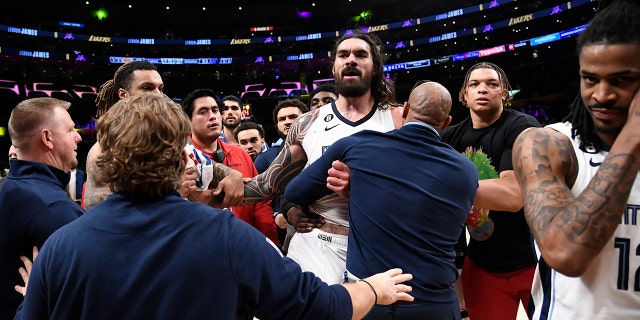 LOS ANGELES, CA - JANUARY 20: Steven Adams #4 of the Memphis Grizzlies is restrained by team trainers and assistant coaches during the halftime against the Los Angeles Lakers at Crypto.com Arena on January 20, 2023 in Los Angeles, California.