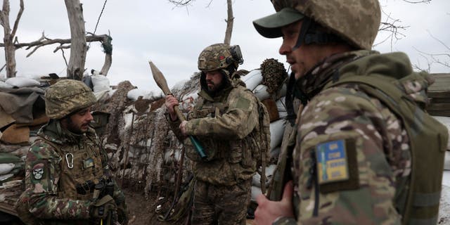 Ukrainian servicemen examine an RPG rocket as they stand in a trench on a frontline position in the Donetsk region on January 23, 2023, amid the Russian invasion of Ukraine.