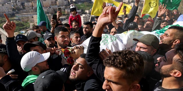 Mourners carry the body of Palestinian youth Yusef Muhaisen, killed by Israeli fire amid clashes, during his funeral in the West Bank town of Al-Ram on Jan. 27, 2023. 