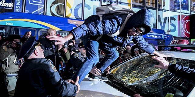 Police officers take a demonstrator, who smashed the window of a police car, into custody at Times Square in New York on Jan. 27, 2023.