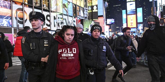 Police officers take demonstrators into custody at Times Square in New York on Jan. 27, 2023.
