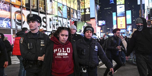 Police officers take demonstrators into custody at Times Square in New York on Jan. 27, 2023.