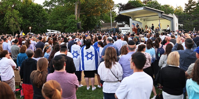 People listen to Joseph Borgen, a recent victim of a hate crime, speak during a rally denouncing anti-Semitic violence on May 27, 2021 in Cedarhurst, New York. 