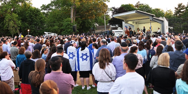 People listen to Joseph Borgen, a recent victim of a hate crime, speak during a rally denouncing anti-Semitic violence on May 27, 2021 in Cedarhurst, New York.